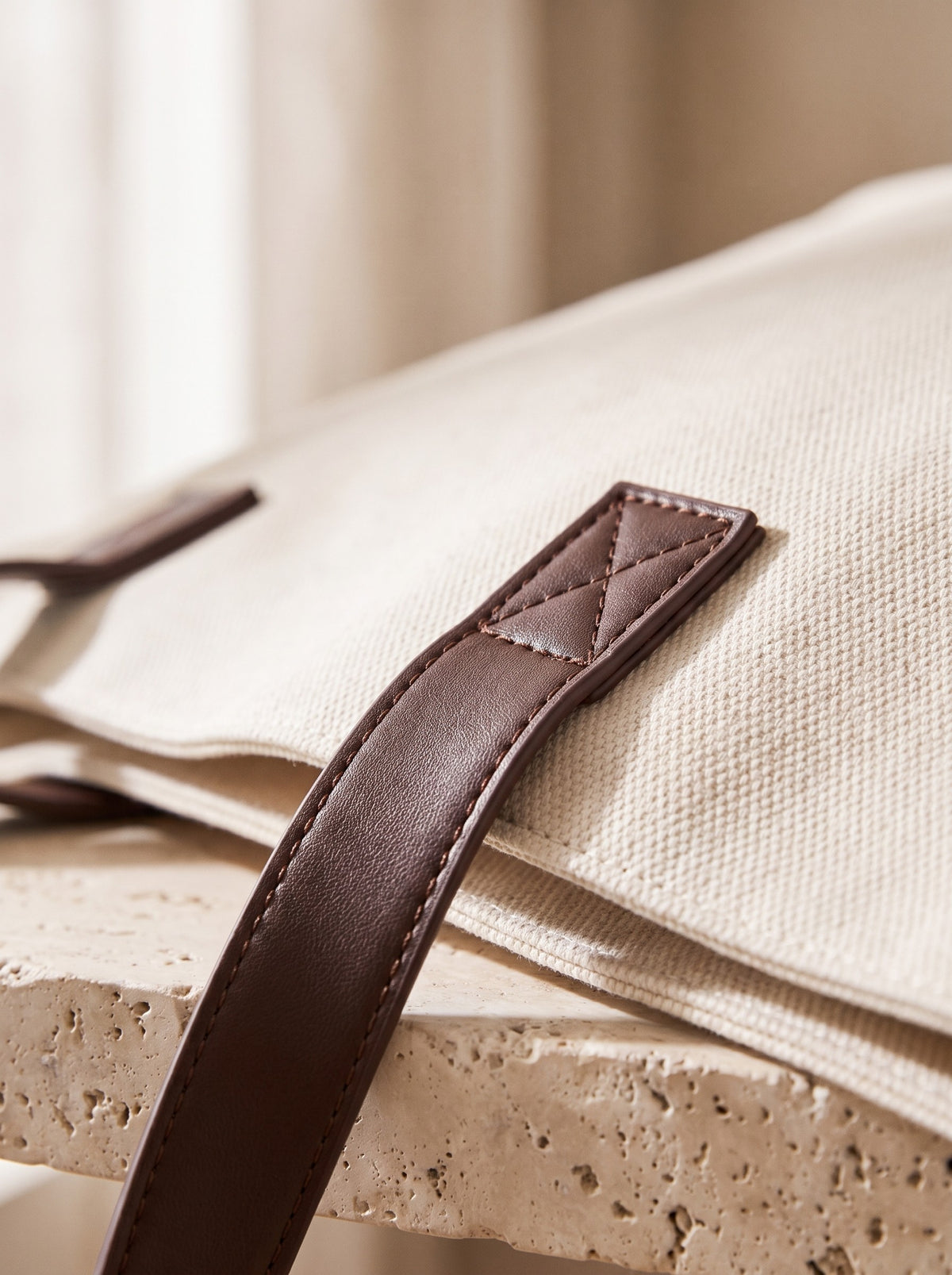 Close-up of the canvas weave and stitched handle tab of the Canvas Weekend Tote