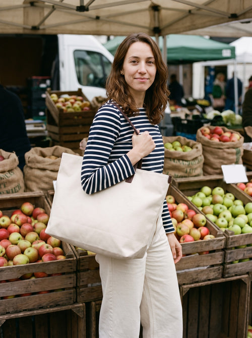 Woman carrying the Canvas Weekend Tote over her shoulder at a market