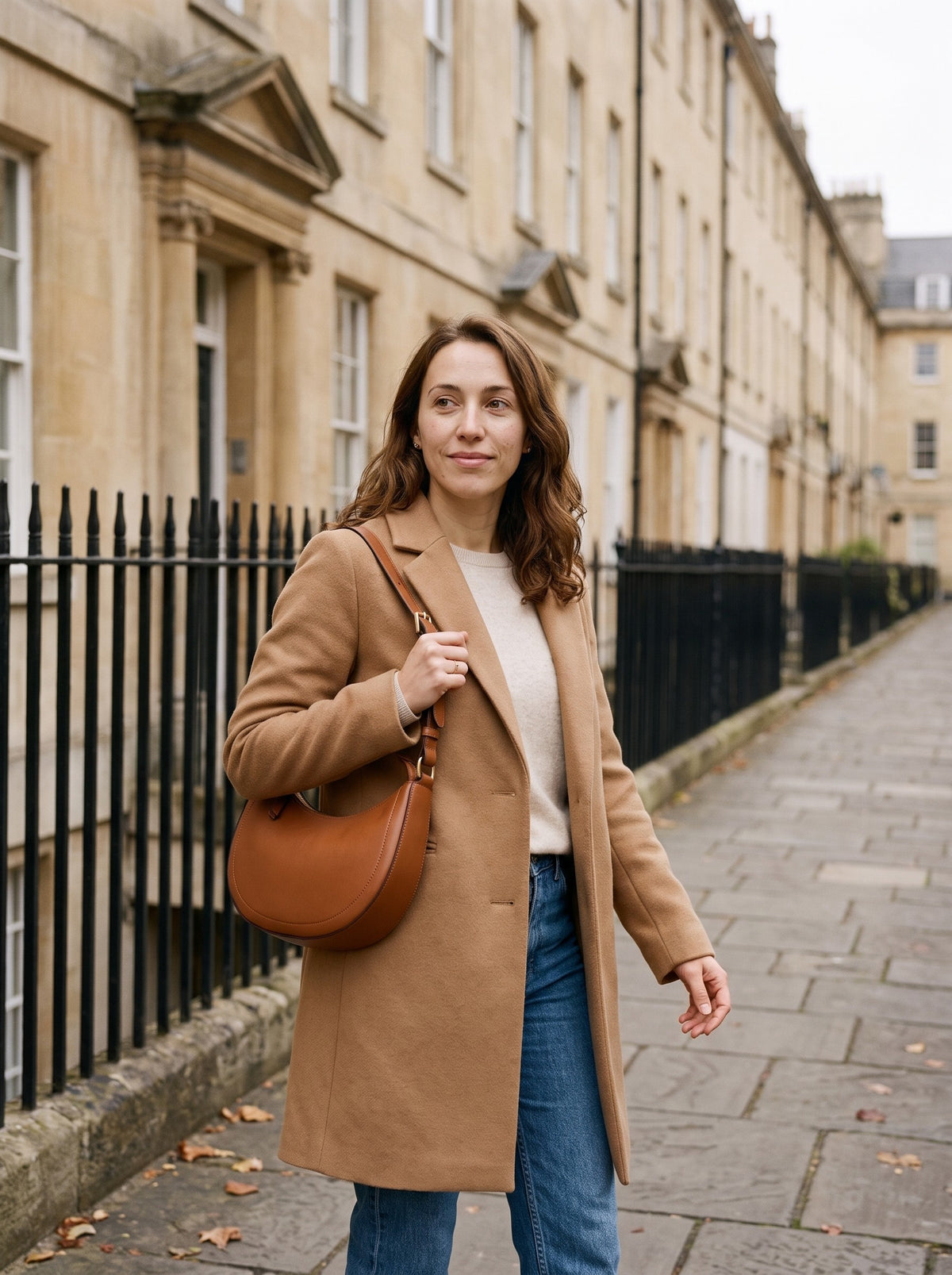 Woman carrying the cognac Crescent Shoulder Bag on her shoulder