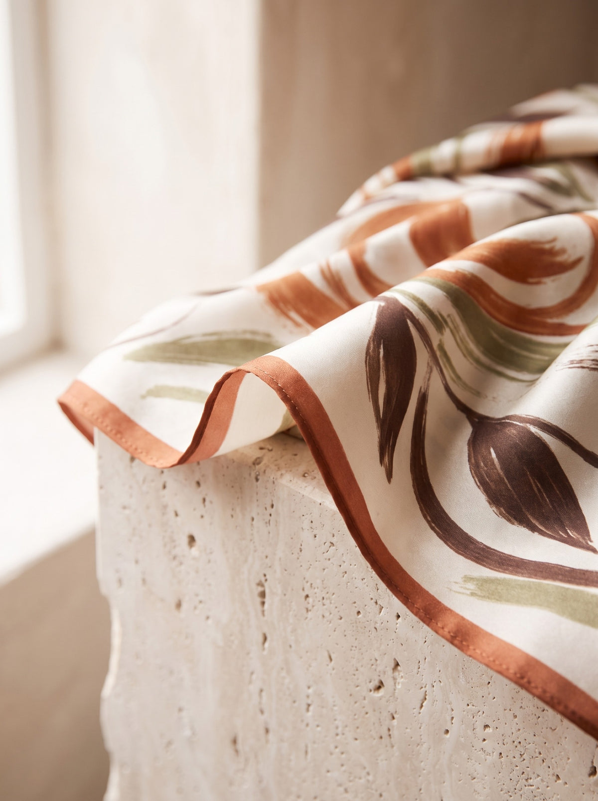 Close-up of the leaf print and rolled edge of the Printed Satin Square Scarf