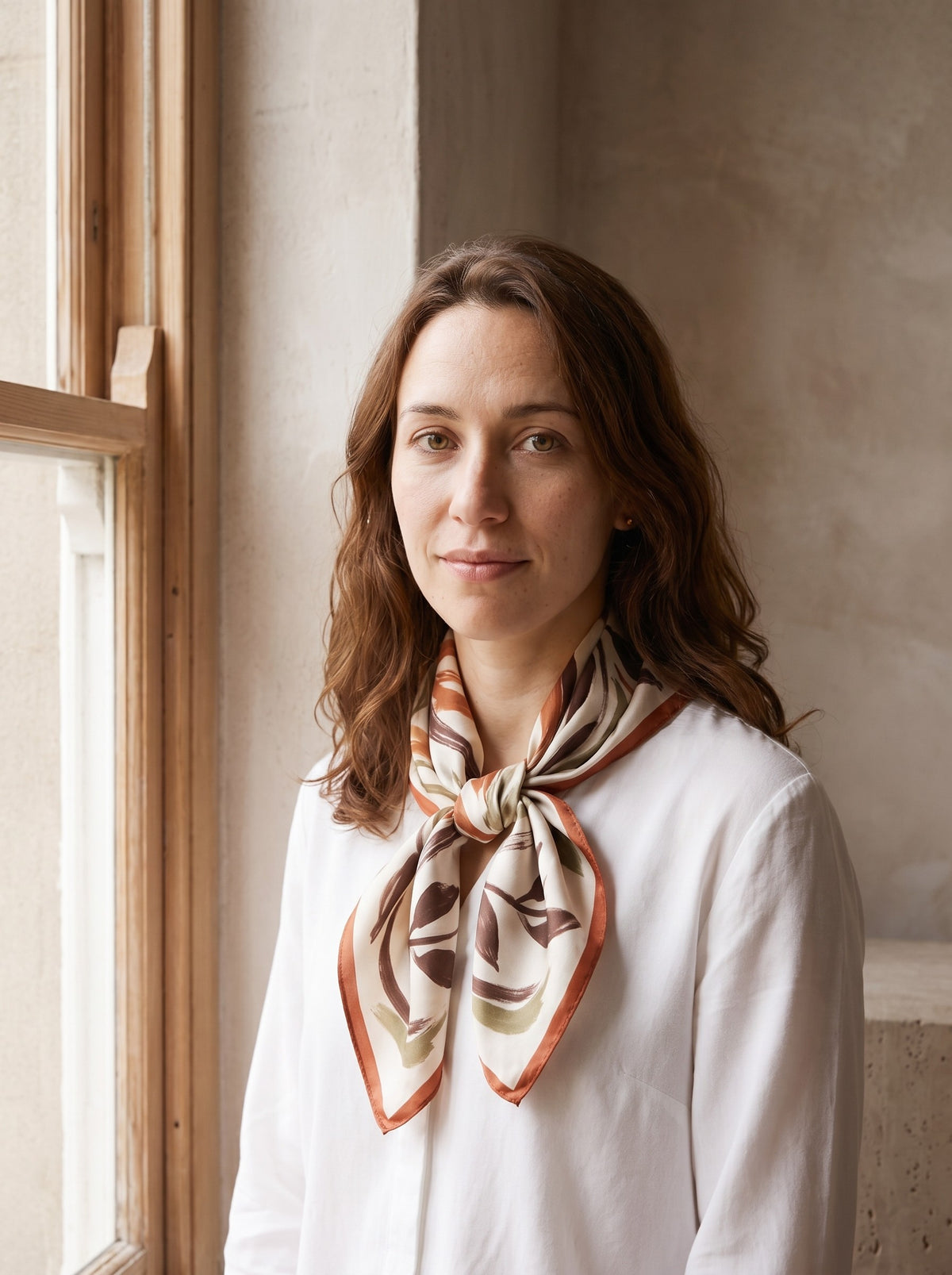 Woman wearing the botanical Printed Satin Square Scarf tied at her neck