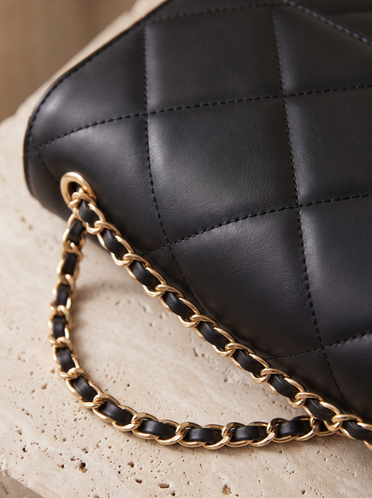 Close-up of the diamond quilting and chain strap of the black Quilted Crossbody Bag