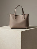 Structured Mini Tote in taupe vegan leather standing on a pale stone plinth